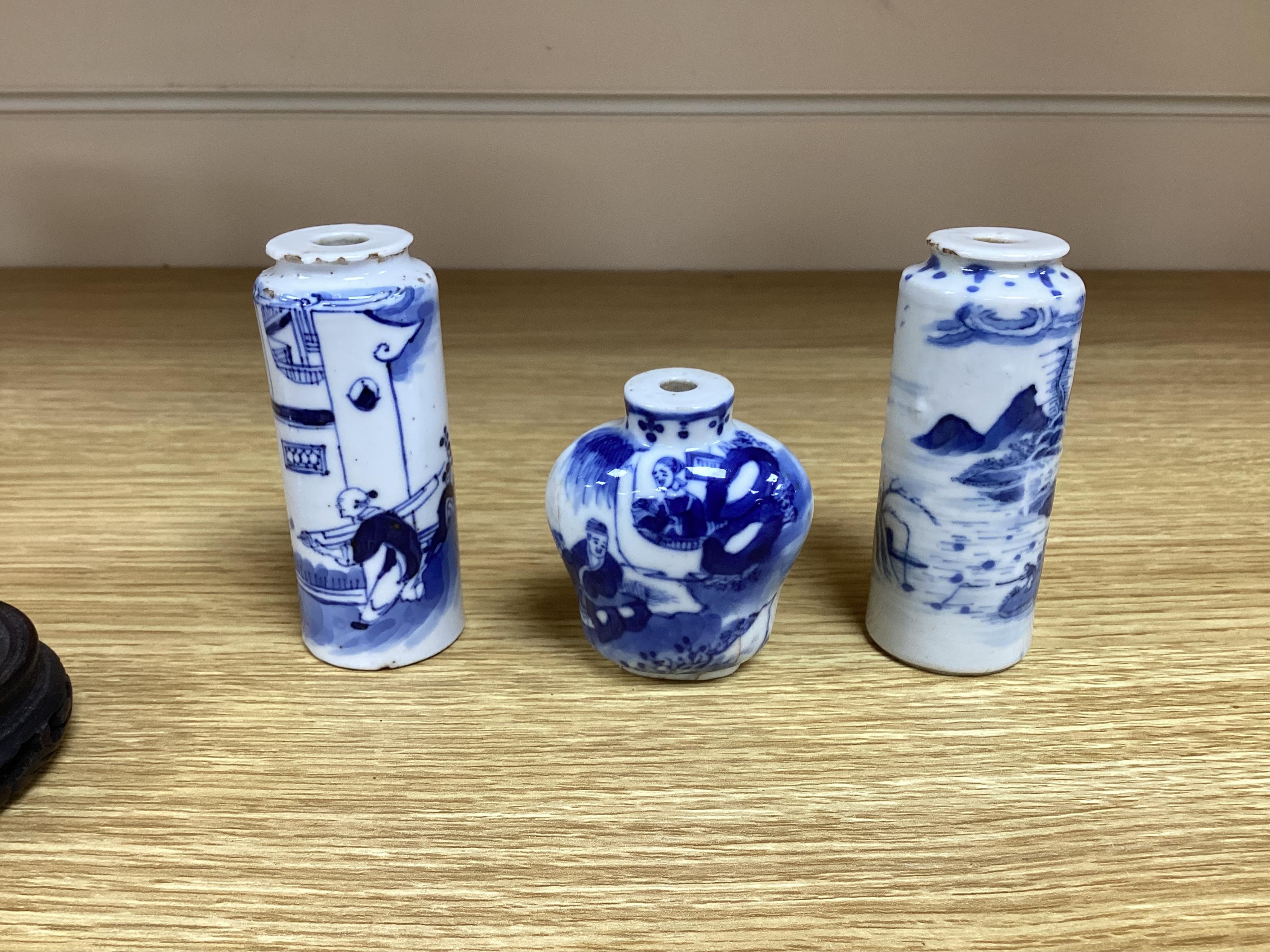 Three Chinese blue and white snuff bottles and three hardwood stands, largest 8cm high. Condition - poor to fair